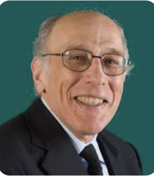 Portrait of Richard Rosenbaum smiling, wearing glasses and a dark suit